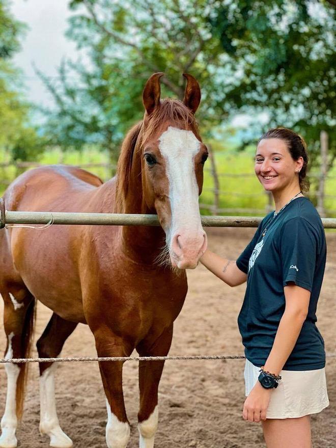 Calm chestnut horse with a white blaze standing beside a guest at Vonfidel Ranch in Sri Lanka