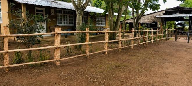 Rustic timber fence and ranch house at Vonfidel Ranch in eastern Sri Lanka