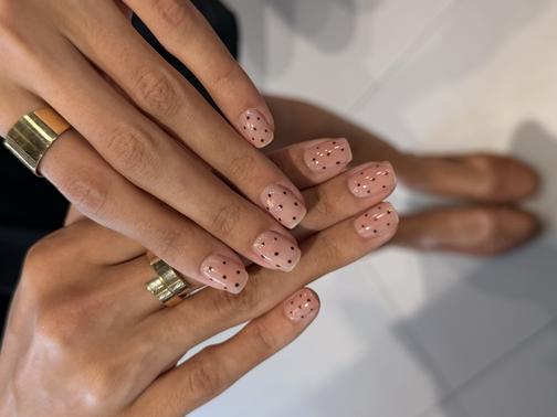 Nude manicure with black polka dots