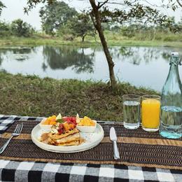 Outdoor breakfast with fruit, juice, and water beside the pond at Vonfidel Ranch